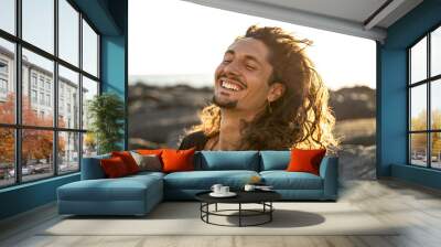 Portrait of happy handsome hippie italian man with long hair smiling beautiful . Freedom. Wanderlust. Tropics. Traveler.Beach. Relax. Wall mural