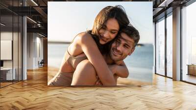 Portrait of lovely couple in love having fun on the beach. Young beautiful people hugging . Romantic moment. Valentine's day. Wall mural