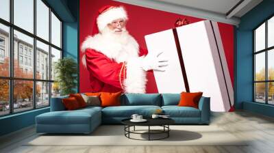 Real Santa Claus smiling,holding big gift box. Wall mural