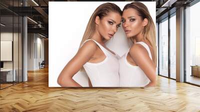 Sensual twins women posing on white background. Wall mural