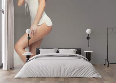 Sensual woman with slim legs posing. Wall mural