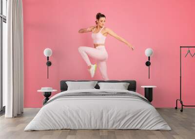 Sporty woman exercising in studio. Wall mural