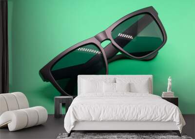 Fashion sunglasses isolated on green background, black plastic. Wall mural