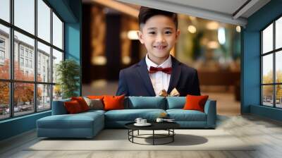 Happy asian boy in suit holding a gift box in shopping mall Wall mural