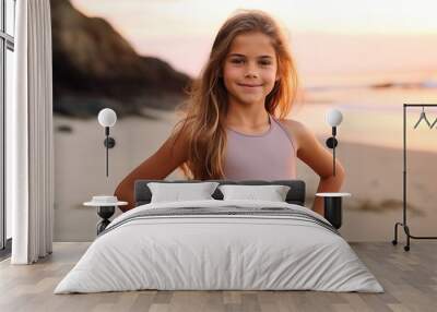 Portrait of a beautiful young girl on the beach at sunset. Wall mural