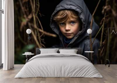 Portrait of a little boy in a dark forest. Shallow depth of field. Wall mural