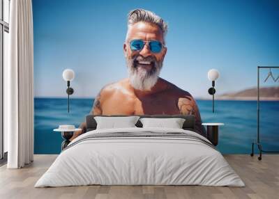 Portrait of happy senior man with tattooed arm standing on the beach Wall mural