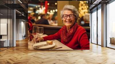 Portrait of happy senior woman sitting in restaurant at christmas time Wall mural