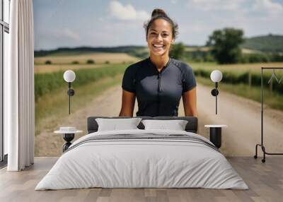 Portrait of smiling young woman in sportswear standing on country road Wall mural