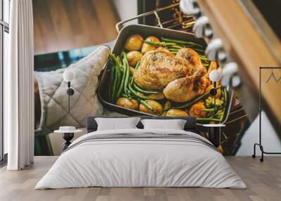 Cook taking ready chicken from the oven Wall mural