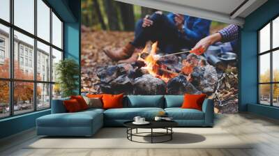 Two young girls girlfriends roasting sweet marshmallow on a fire in the evening in the autumn forest. Wall mural