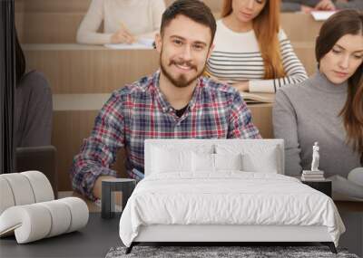 Handsome young man studying in university auditorium Wall mural