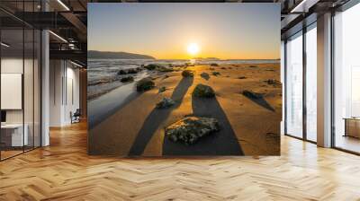 Red sky over a rocky seashore. Sunset landscape. Wall mural