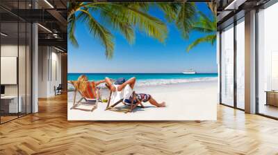 Couple on a tropical beach in the Maldives with cruise ship passing by Wall mural