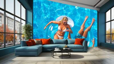 couple outside relaxing in swimming pool in the summertime Wall mural