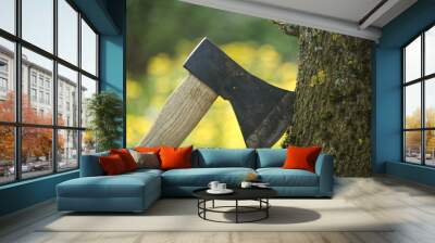 Axe stuck in tree stump in background of felled forest Wall mural