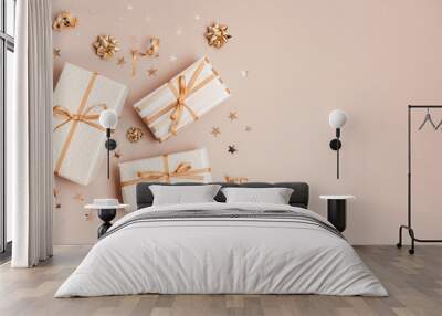 Christmas background with gift boxes wrapped in golden colored paper. Xristmas celebration, preparation for winter holidays. Festive mockup, top view, flat lay Wall mural