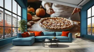 Cozy autumn baking in a warm kitchen with a person preparing a delicious apple pie Wall mural