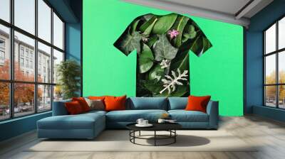 Paper cut t-shirt shape filled with green leaves. Organic cotton production, sustainable, ethical shopping, slow, circular fashion concept Wall mural