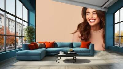 Portrait of a young latin woman with pleasant smile over beige backgroundl with copy space. Beautiful girl in warm sweater Wall mural