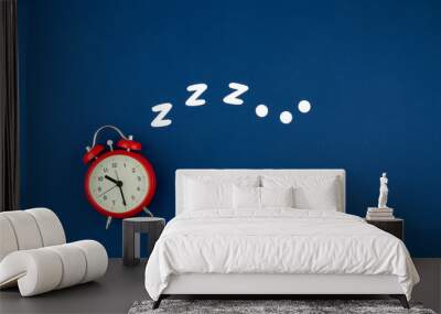 Snoring classic alarm clock on blue pastel trendy background. Flat lay, top view mock up Wall mural