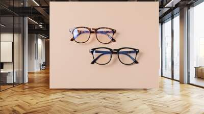 Stylish eyeglasses over pastel background. Optical store, glasses selection, eye test, vision examination at optician, fashion accessories concept. Top view, flat lay Wall mural