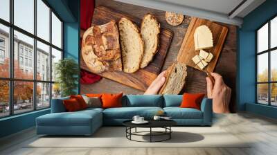 Woman hands cut fresh organic artisan bread. Healthy eating, buy local, homemade bread recipes concept. Top view, flat lay Wall mural