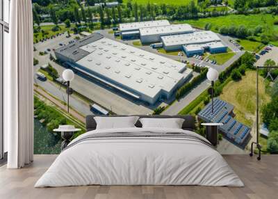 Aerial view of goods warehouse. Logistics center in industrial city zone from above. Aerial view of trucks loading at logistic center. View from drone. Wall mural