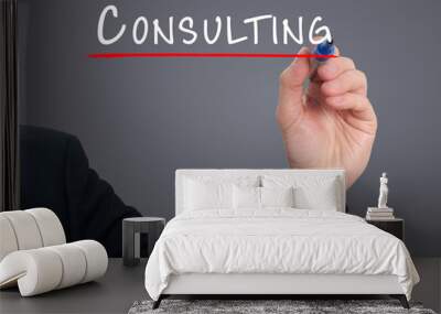 Businessman hand writing Consulting. Grey background. Wall mural