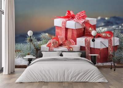 Decoratively wrapped Christmas gifts with red and white ribbons on a snowy wooden table against a mountain backdrop at dusk Wall mural