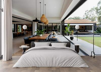 Modern Interior Design with a Rustic Wooden Table, Black Chairs and a Large Window Looking Out to a Backyard with a Swimming Pool and Lush Greenery Wall mural