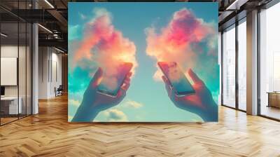 Two Hands Holding Smartphones with Colorful Clouds Reflecting on Screens in a Blue Sky Wall mural