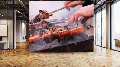 
a man roasts meat on a fire.
Close-up of hands and shish kebab.
Cooking pork neck on the grill. Roasted carrots. Fatty food, festive food of the CIS countries. May 1, labor day. Not vegan food. Wall mural