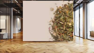 Banner with pile of healthy herbs near a cup of herb tea isolated at solid green background with copy space. Concept healthy diet, supplements, and food Wall mural