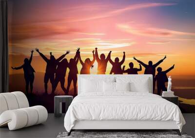 A group of people celebrating with raised arms against a vibrant sunset background.  Wall mural