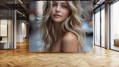 A young woman with long, wavy blonde hair poses softly in an urban street setting, showcasing natural beauty and confidence.  Wall mural