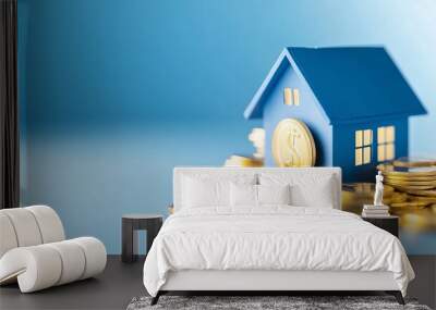 A blue house model sitting on a pile of gold coins, representing real estate investment and financial growth. Wall mural