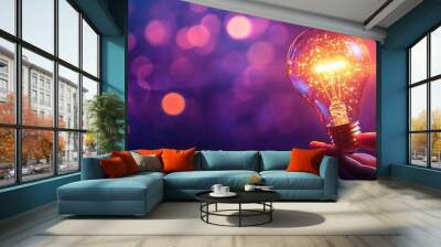 A glowing light bulb held in hand, radiating warm sparkles against a dreamy purple backdrop, symbolizing creativity and innovation. Wall mural