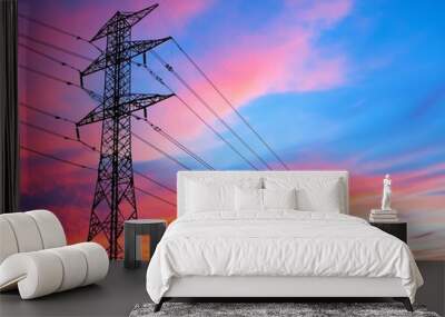 A stunning sunset showcases vibrant colors behind a power line tower, creating a captivating silhouette against the sky. Wall mural