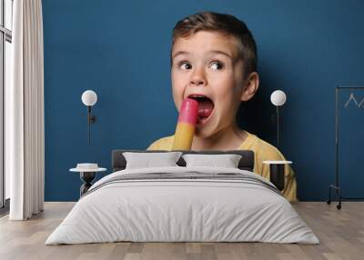 Adorable little boy with delicious ice cream against color background Wall mural