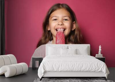 Adorable little girl with delicious ice cream against color background Wall mural