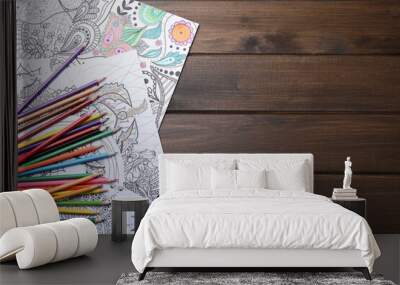 Antistress coloring pages and pencils on wooden table, flat lay. Space for text Wall mural