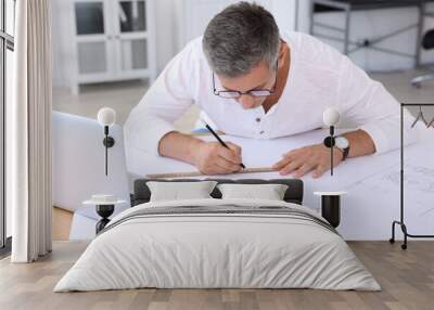 Architect making engineering drawing at wooden table in office Wall mural