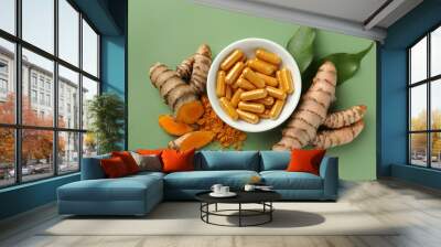 Aromatic turmeric powder, pills and raw roots on green background, flat lay Wall mural