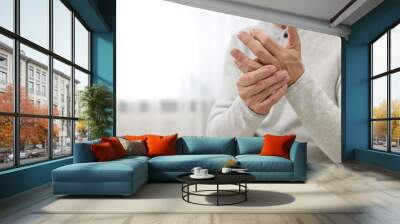 Arthritis symptoms. Man suffering from pain in hand at home, closeup. Space for text Wall mural