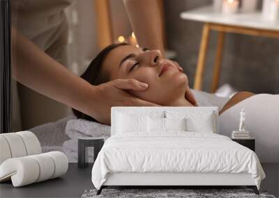 Attractive woman enjoying face massage in spa salon, closeup Wall mural