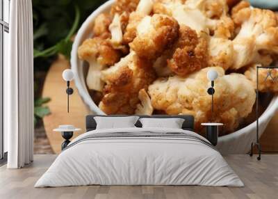 Baked cauliflower in bowl on wooden table, closeup Wall mural