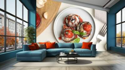 Baked eggplant with tomatoes, cheese and basil served on white wooden table, flat lay Wall mural