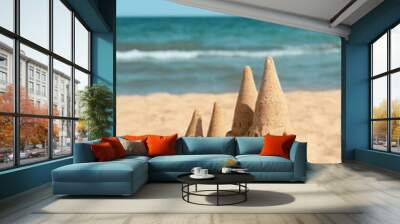 Beach with sand castle near sea on sunny day Wall mural