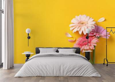 beautiful gerbera flowers and petals on yellow background, flat lay. space for text Wall mural